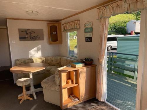 2 bedroom cosy caravan في بورث: غرفة معيشة مع أريكة وطاولة في كرفان