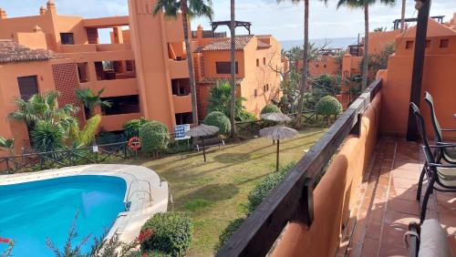 a view from the balcony of a building with a swimming pool at Jardines, piscina y mar in Estepona