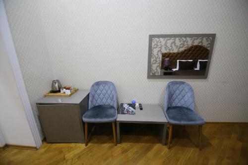 une table avec deux chaises et un bureau avec un miroir dans l'établissement Prime Hotel, à Baku