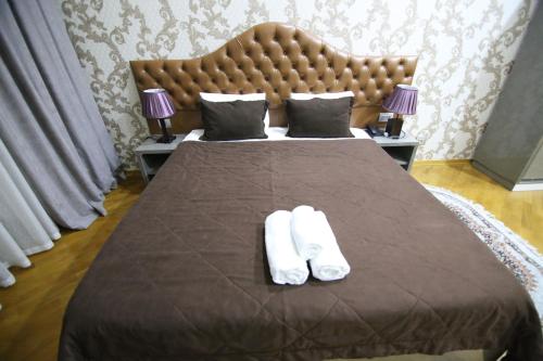 a bedroom with a bed with two white towels on it at Prime Hotel in Baku