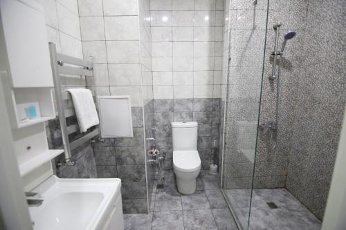 a bathroom with a shower and a toilet and a sink at Prime Hotel in Baku