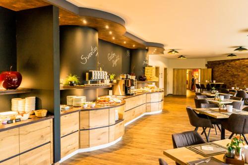 a restaurant with tables and chairs and a cafeteria at Landhotel Lebensart in Xanten