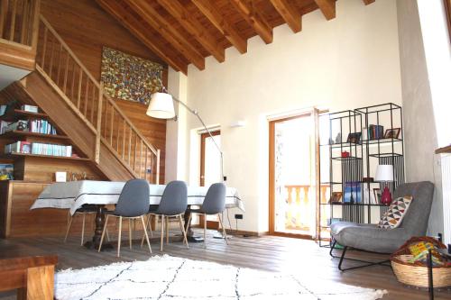 a living room with a table and chairs and a staircase at Morge La Salle in La Salle