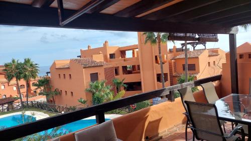 a balcony with a view of a building and a swimming pool at Jardines, piscina y mar in Estepona
