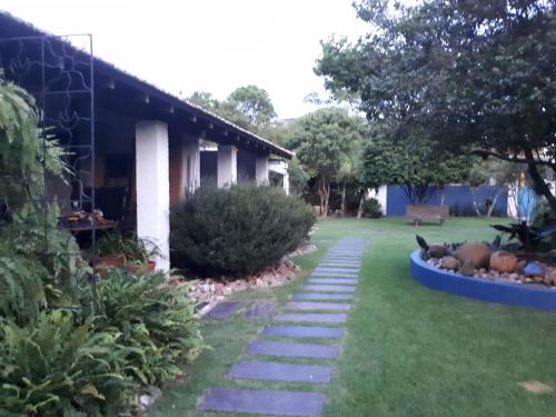 a garden with a walkway next to a house at O Vilarejo - Lagoa da Conceição in Florianópolis