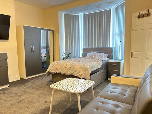 um quarto com uma cama e um sofá em Ensuite Room with Private Bathroom at Walsall em Walsall