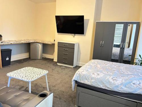 um quarto com uma cama e uma televisão na parede em Ensuite Room with Private Bathroom at Walsall em Walsall