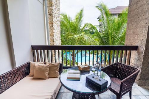 a balcony with a table and chairs and the ocean at Royal Tulip Springhill Resort Jimbaran in Jimbaran