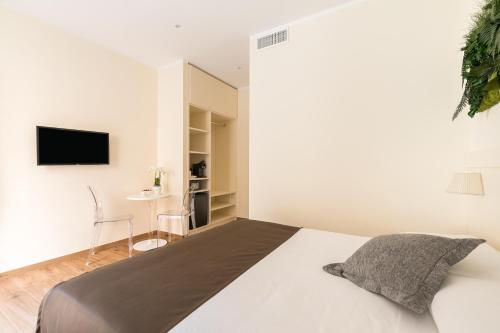 um quarto com uma cama e uma televisão na parede em Borghetto Guest House em Roma