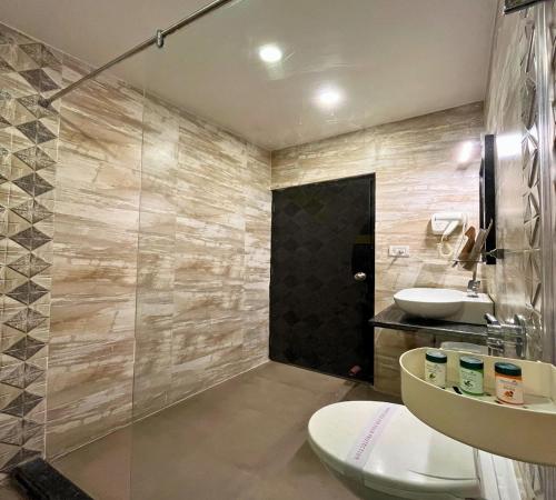 a bathroom with a shower and a toilet and a sink at Hotel Runway Inn in Pura Raghunāth