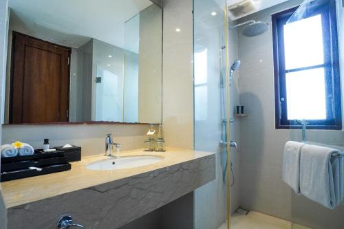 a bathroom with a sink and a mirror at Royal Tulip Springhill Resort Jimbaran in Jimbaran