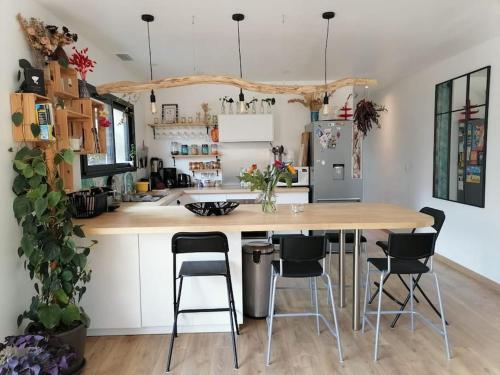 une cuisine avec une grande table et des chaises en bois dans l'établissement La Z family, logement vacances 5 couchages, centre ville et plage à pieds, à Lacanau