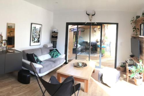 un salon avec un canapé et une table dans l'établissement La Z family, logement vacances 5 couchages, centre ville et plage à pieds, à Lacanau