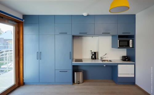 a kitchen with blue cabinets and a sink at La Ferme Des Ailleurs in Arleux-du-Nord
