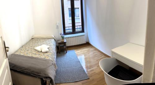 Kleines Zimmer mit einem Bett und einem Schreibtisch. in der Unterkunft Bonito piso a 500m de la Catedral in León