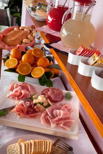 a table topped with different types of food on plates at My Home Hotel in Bellaria-Igea Marina