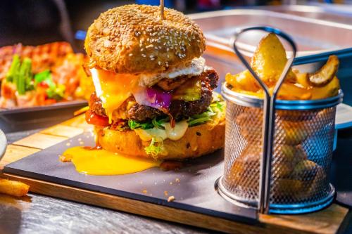a hamburger with cheese and a can of fries at Landhotel Lebensart in Xanten