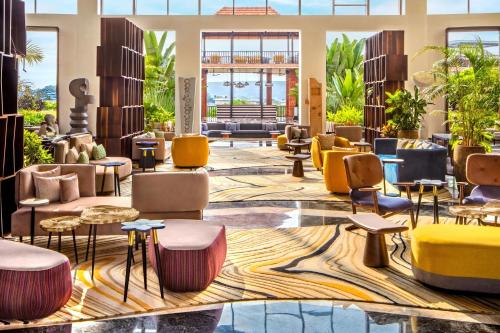 a lobby with colorful chairs and tables at The Westin Goa in Vagator