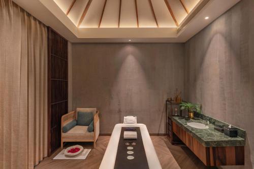 a bathroom with a tub and a sink and a chair at The Westin Goa in Vagator