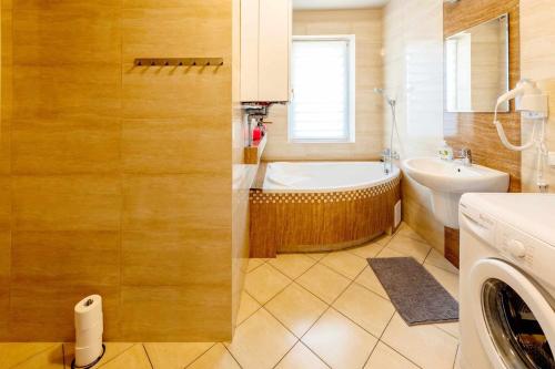 a bathroom with a tub and a toilet and a sink at Apartamenty Straconka 3,Bielsko-Biala in Bielsko-Biała
