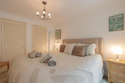 a bedroom with a large white bed with pillows at Sandy Castle in Southwold