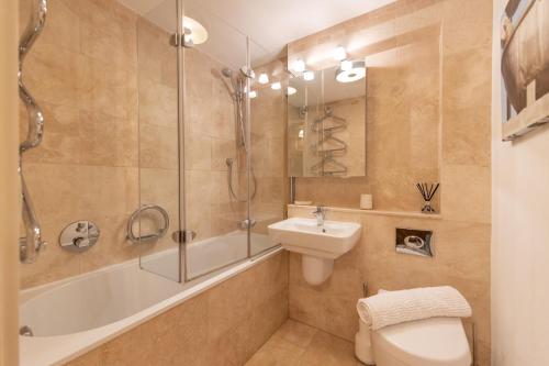 a bathroom with a tub and a sink and a toilet at Sandy Castle in Southwold