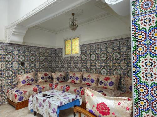 een woonkamer met een bank en een tafel bij Dar Ba sidi in Rabat