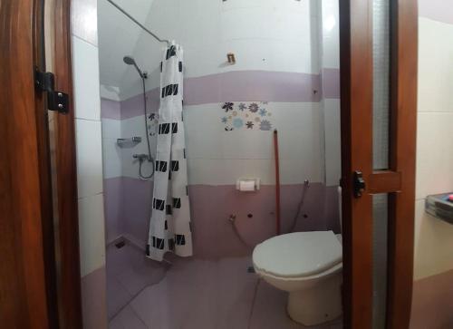 y baño con aseo y cortina de ducha. en Dar Ba sidi, en Rabat