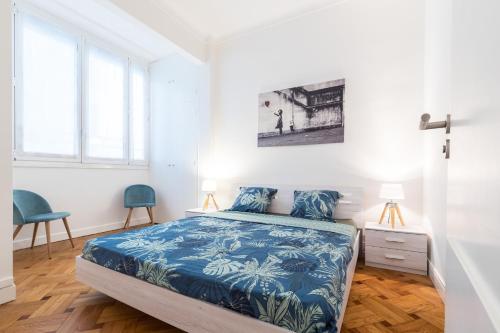 a bedroom with a bed and two blue chairs at Promenade des Anglais 2 Bdr Large Terrace in Nice