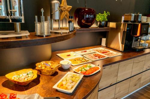 a buffet with different types of food on a counter at Landhotel Lebensart in Xanten
