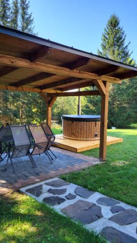 a wooden pavilion with two chairs and a fire pit at Chata Krpko in Horná Lehota