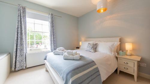 ein Schlafzimmer mit großem Bett und Fenster in der Unterkunft Palmer's Cottage in Southwold