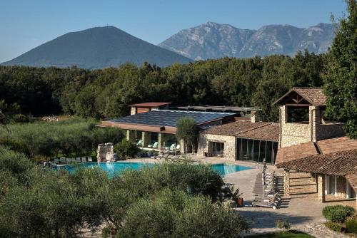 une maison avec une piscine et des montagnes en arrière-plan dans l'établissement Aquapetra Resort & Spa, à Telese
