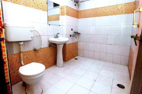 a bathroom with a toilet and a sink at New Jain Residency Inn Madhya Pradesh in Pachmarhī