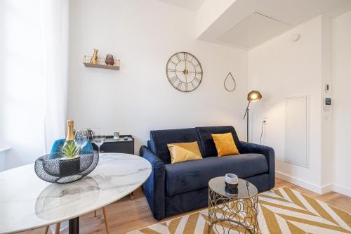 un salon avec un canapé bleu et une table dans l'établissement Charming City Center Studio 104, à Nice