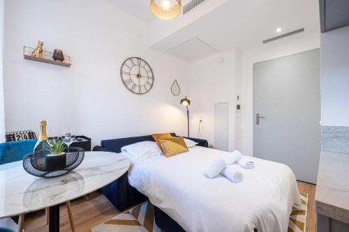 - une chambre avec un lit, une table et une horloge dans l'établissement Charming City Center Studio 104, à Nice