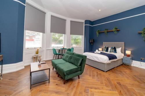 - une chambre avec des murs bleus, un lit et une chaise verte dans l'établissement King Size Bed I Central Location I Smart TV, à Brighton et Hove