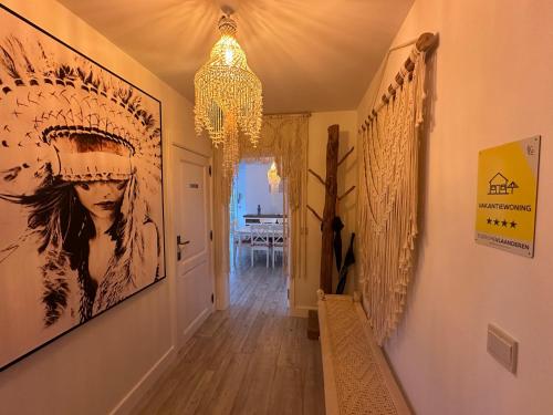 a hallway with a chandelier and paintings on the walls at TOP appartement met garage "Au Franelle" in Ostend