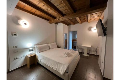 a bedroom with a white bed and a television at Bes Residence Bergamo Polaresco in Bergamo