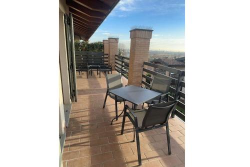 a patio with tables and chairs on a balcony at Bes Residence Bergamo Polaresco in Bergamo