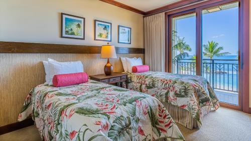two beds in a hotel room with a balcony at Ko Olina Beach Villas B410 in Kapolei