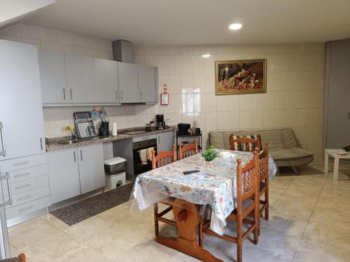 eine Küche und ein Esszimmer mit einem Tisch und Stühlen in der Unterkunft Casinha Miradouro in Vila Nova de Gaia