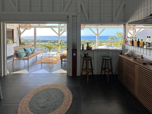 a kitchen and living room with a view of the ocean at Villa Calysta in Deshaies