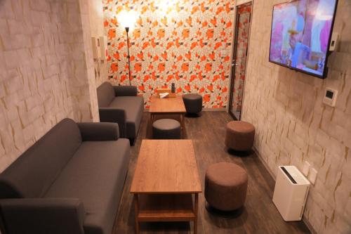 a living room with a couch and tables and a tv at 台東区浅草もすぐ,最大10名貸切3階建て,スカイツリーまで徒歩10分,全室Chromecast完備,WonderfulStayTOKYO SKYTREE in Tokyo