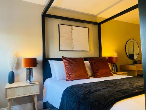 a bedroom with a king sized bed with a black frame at The Punchbowl Lapworth in Solihull