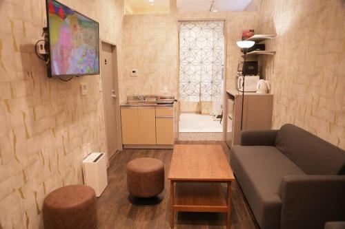a living room with a couch and a table and a kitchen at 台東区浅草もすぐ,最大10名貸切3階建て,スカイツリーまで徒歩10分,全室Chromecast完備,WonderfulStayTOKYO SKYTREE in Tokyo