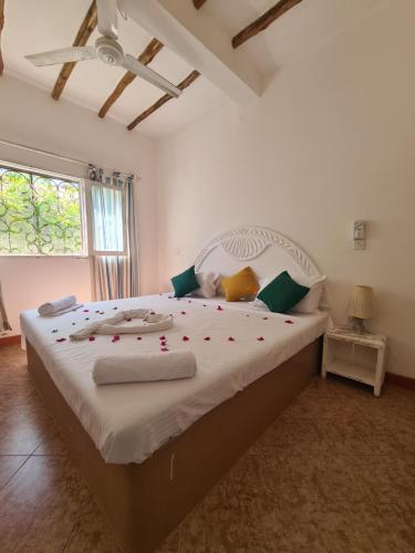 una camera da letto con un grande letto con rose rosse di Villa Yasmin a Watamu