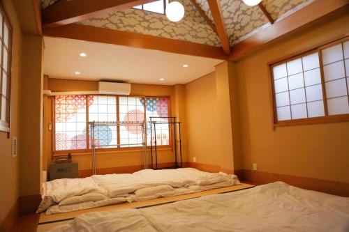 two beds in a room with two windows at 台東区浅草もすぐ,最大10名貸切3階建て,スカイツリーまで徒歩10分,全室Chromecast完備,WonderfulStayTOKYO SKYTREE in Tokyo
