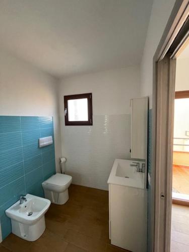a bathroom with a toilet and a sink at case al borgo in Porto Pollo