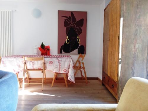 a dining room with a table and chairs and a painting at Morge La Salle in La Salle